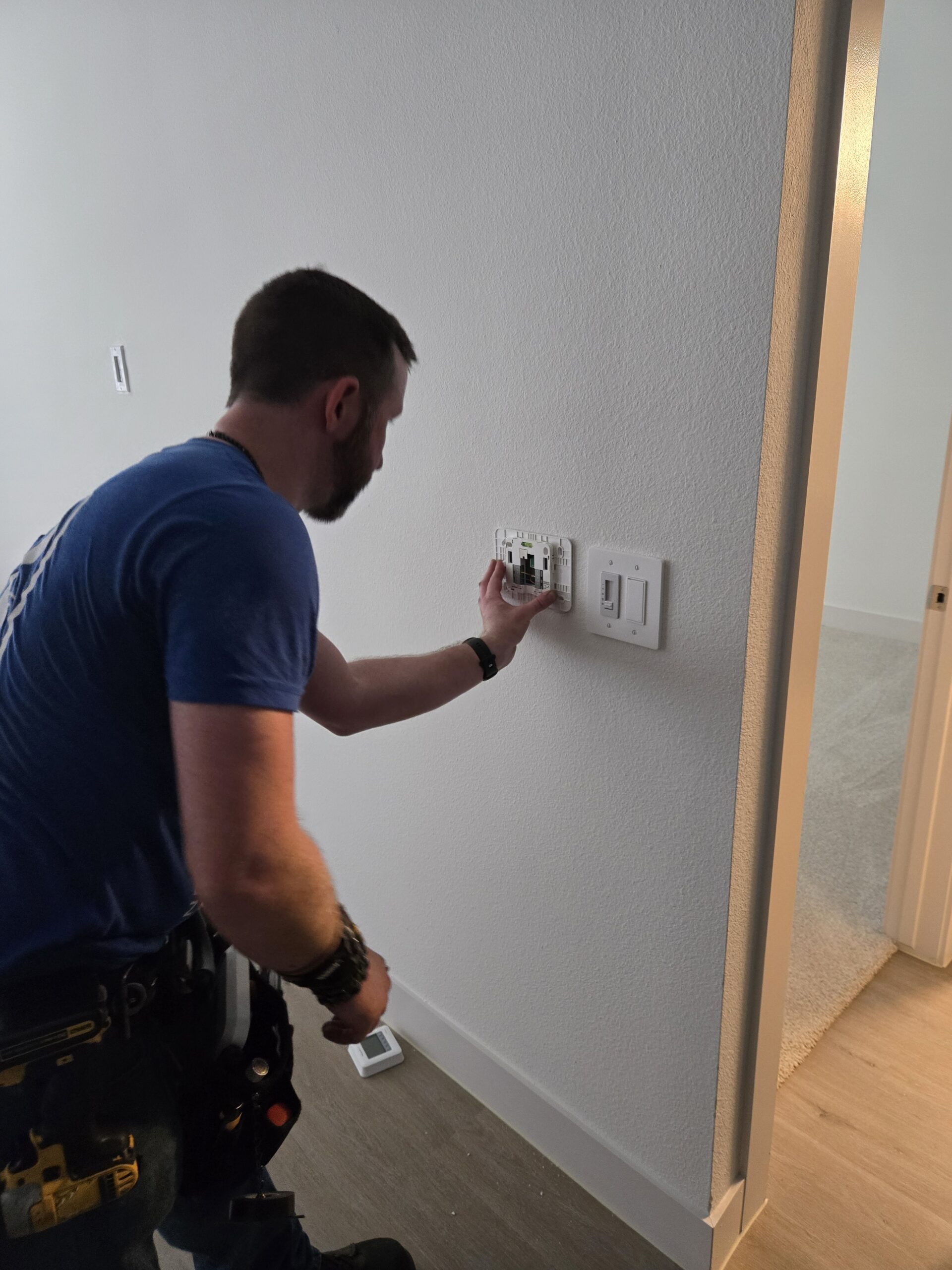 Security technician programming door reader and testing controlled commercial entry system
