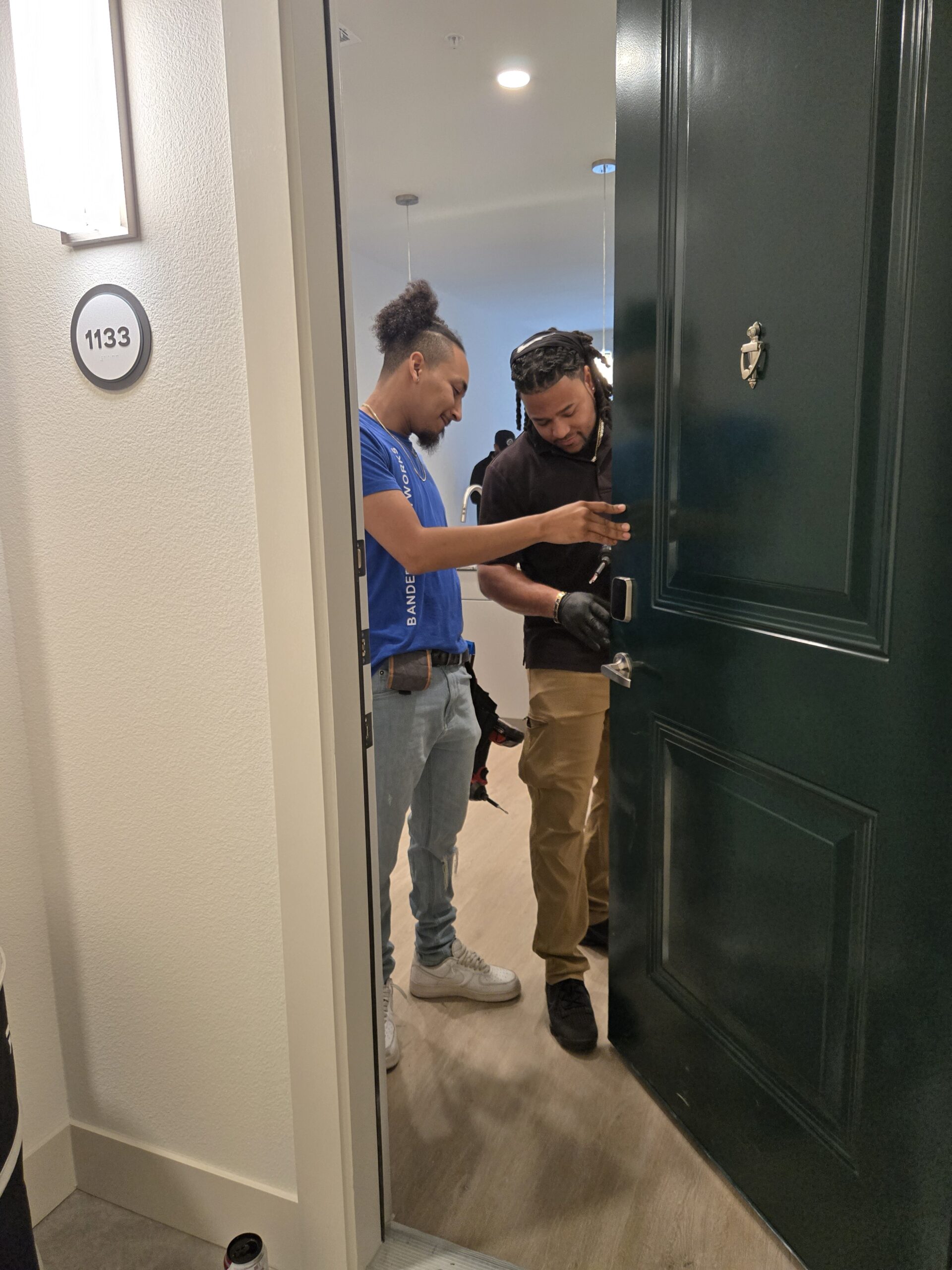 Security technician testing camera angles and entry sensors with professional setup tools