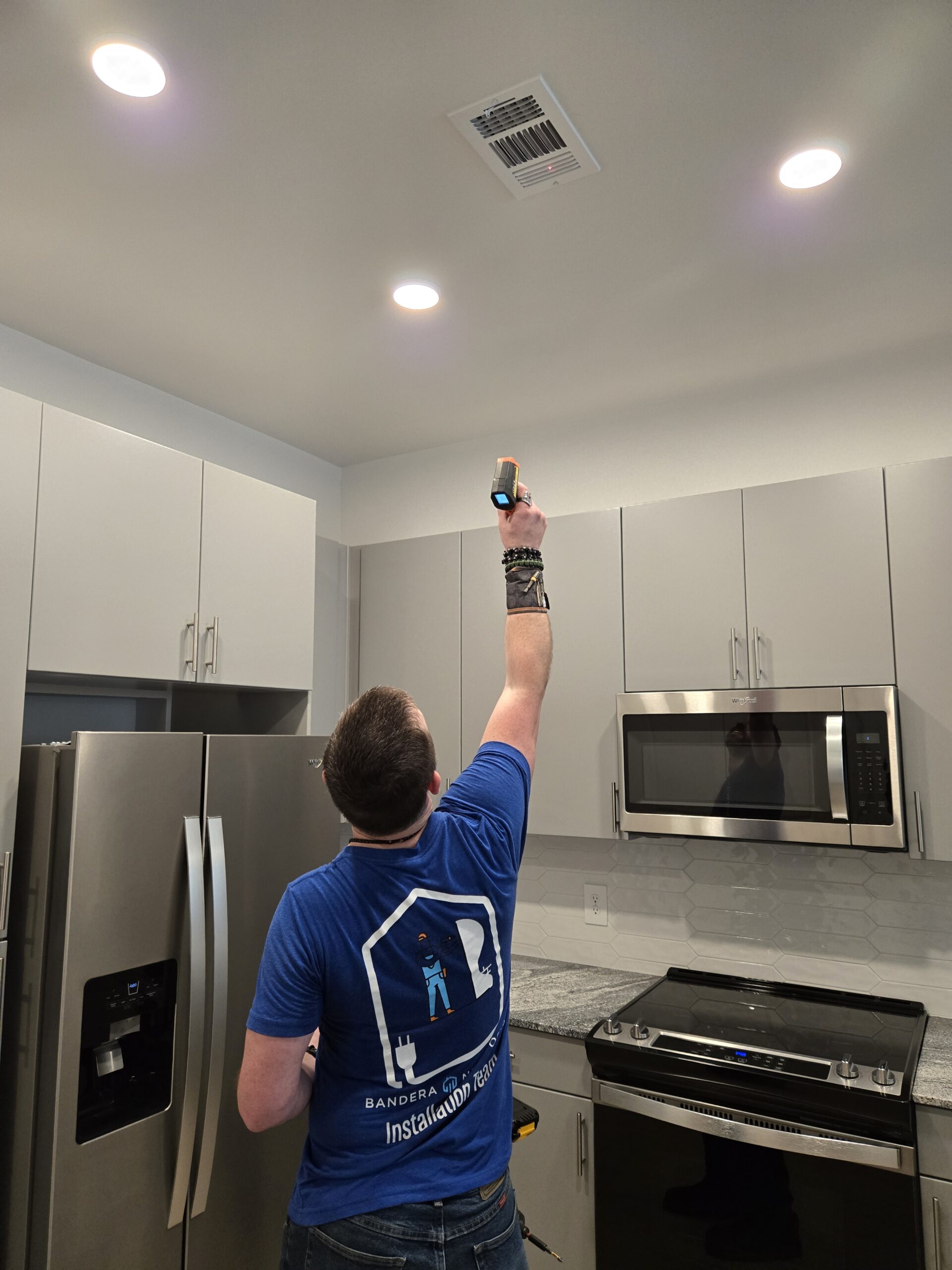 Resident adjusting smart thermostat and lighting in a modern apartment living room