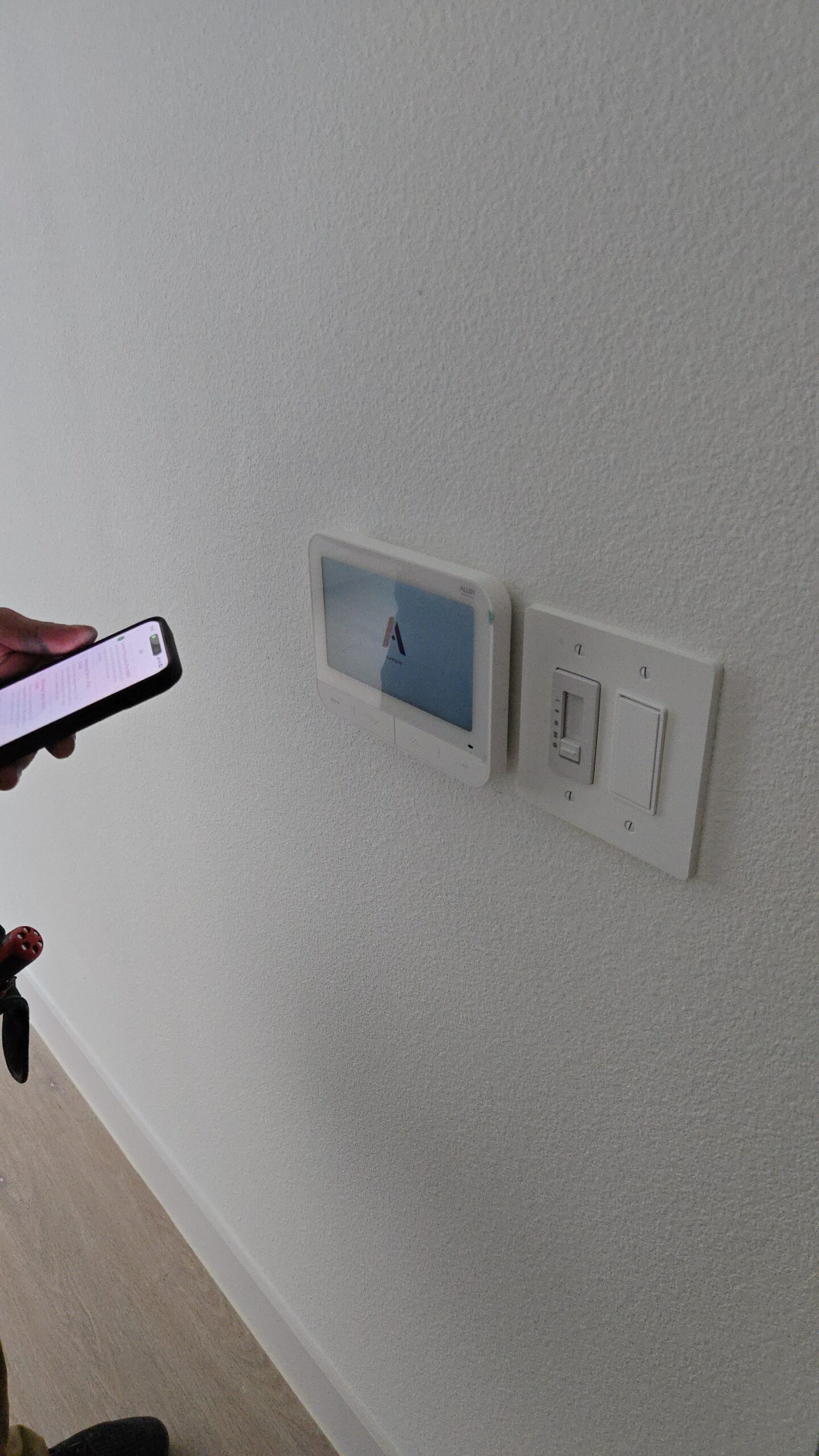 Security technician programming door reader and testing controlled commercial entry system, Family reviewing mobile security alerts after package delivery at front porch