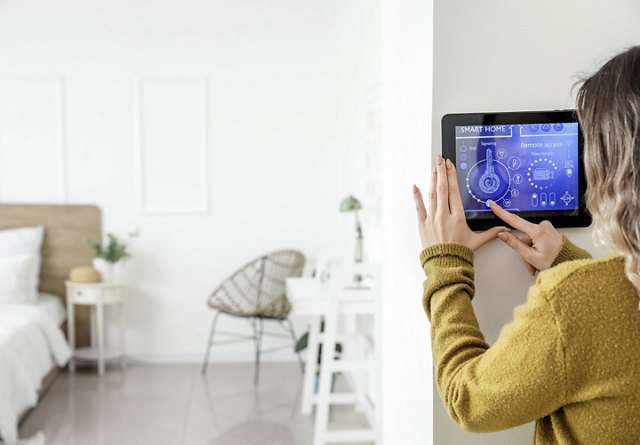 Security technician programming door reader and testing controlled commercial entry system, Installer configuring whole-home lighting and security controls in a newly renovated Dallas County residence